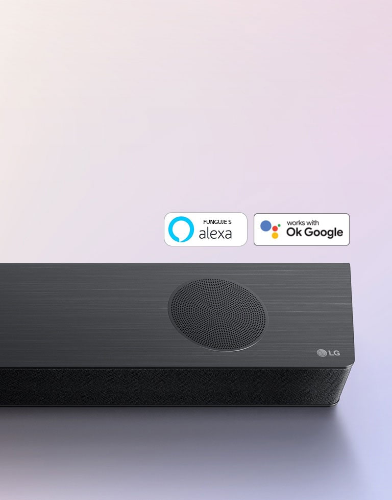 Zvukový panel LG je umiestnený na zemi a zobrazuje logo LG v pravom rohu panelu. Na zvukovom paneli sú umiestnené logá Alexa a OK GOOGLE.