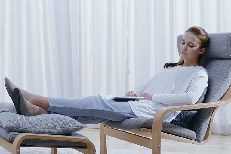 Žena sediaca na stoličke relaxovať doma