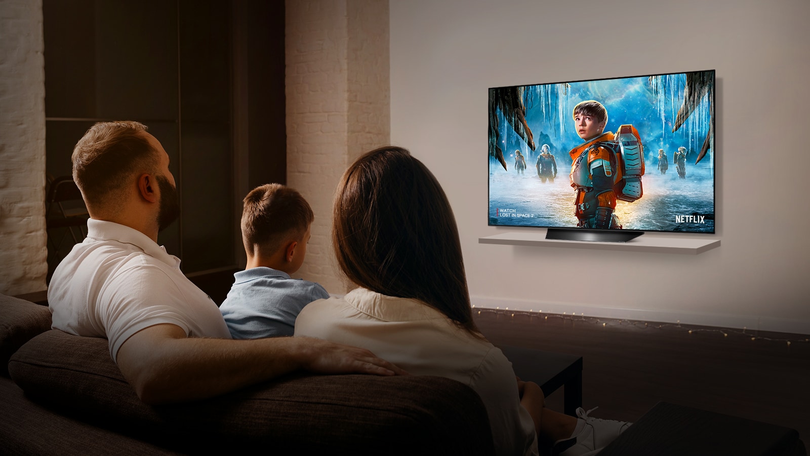 Pár sediaci na pohovke v obývacej izbe sleduje na televízore romantický film