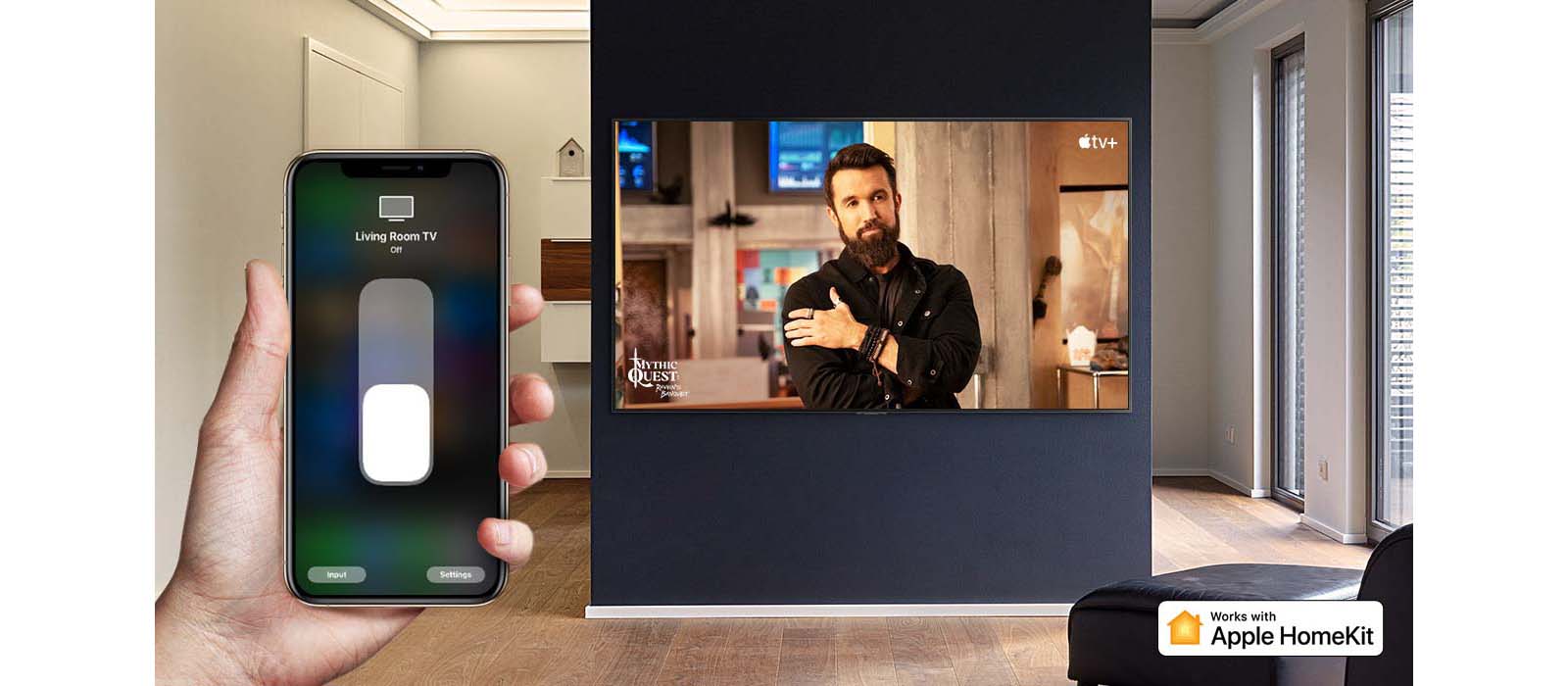 Záber zblízka na ruku ovládajúcu televízor cez zariadenie iPhone, pričom na televízore sa zobrazuje obsah Apple TV+