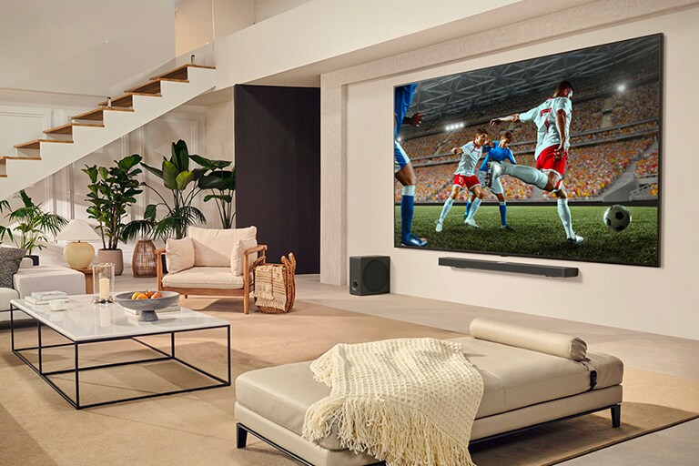Une famille est rassemblée autour de leur LGTV ultra large et regarde un match de football passionnant sur le très grand écran.