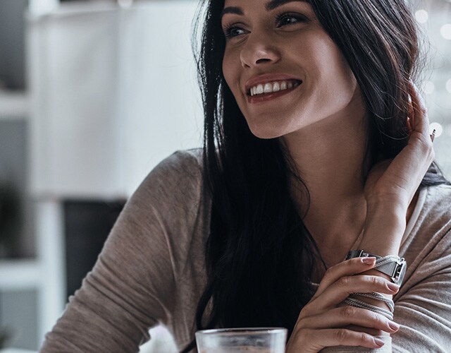 Une femme fixe quelque chose avec un grand sourire.
