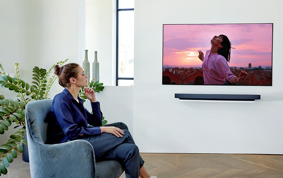 Une femme regarde la télévision sur son fauteuil