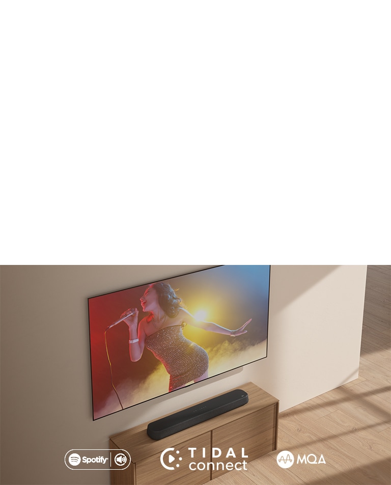 LG 電視掛在牆上。螢幕上有一名身穿短洋裝的女子，右手拿著麥克風，在紅黃藍三色的燈光下唱歌。Soundbar置於正下方。