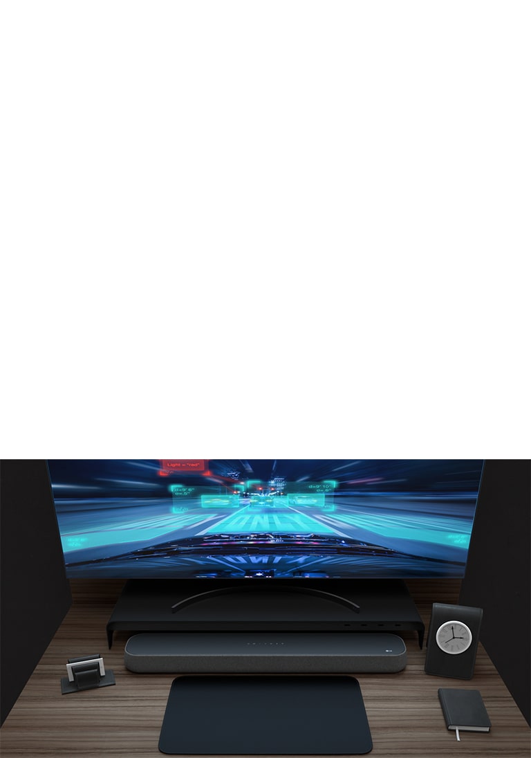 木桌上放著soundbar、曲面顯示螢幕、一張便條還有一個小時鍾。顯示螢幕上正在播放賽車遊戲的畫面，以展示適合遊戲的功能。