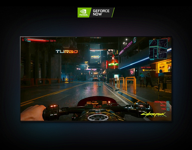 在 LG OLED 電視上顯示的《電馭叛客 2077》場景，玩家駕駛摩托車穿過霓虹燈照亮的街道。