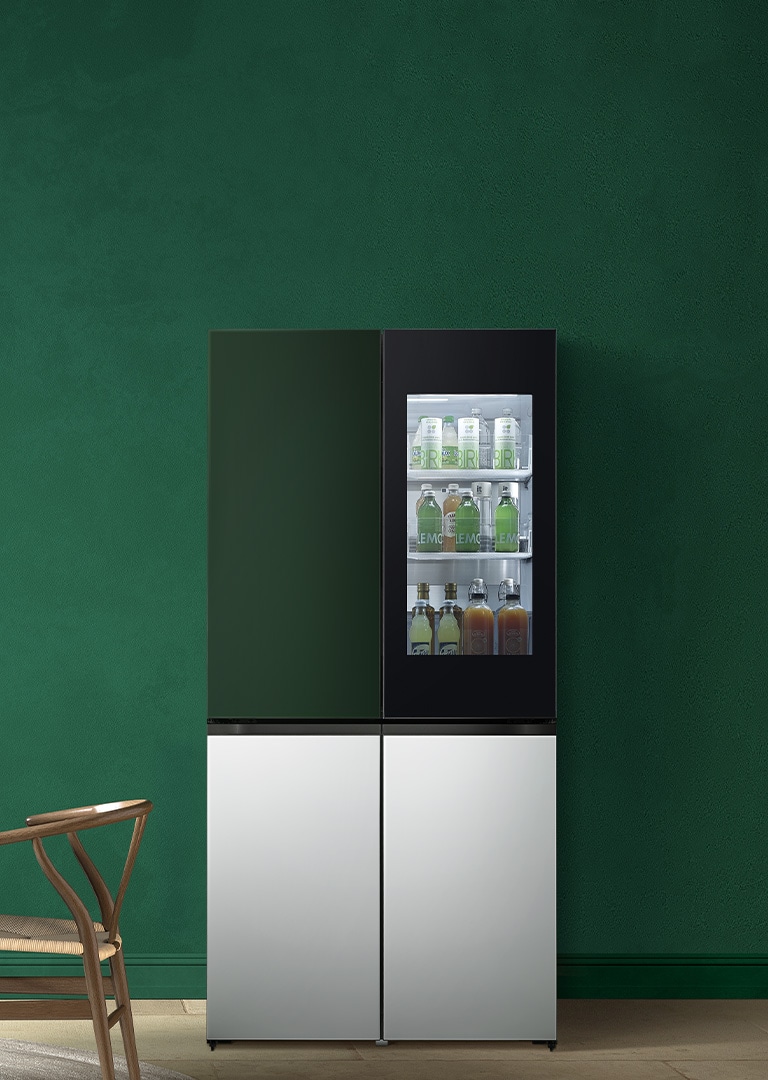 A multi-door refrigerator and top freezer are placed on the right side of the green space. And a white curtain, beige pot, and dark wooden table and chairs are placed on the left side.