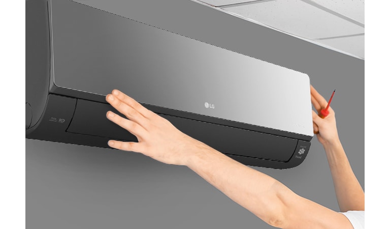 Вид збоку на кондиціонер, що встановлюють на стіні майже під стелею. Дві руки тягнуться вгору, одна тримає викруеку, демонструючи легкість встановлення.