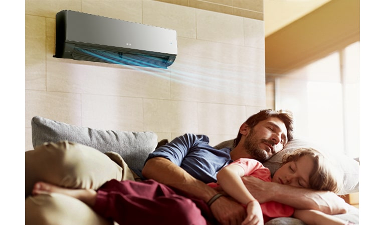 Батько з донькою сплять на дивані під кондиціонером, який випускає повітря блакитного кольору.