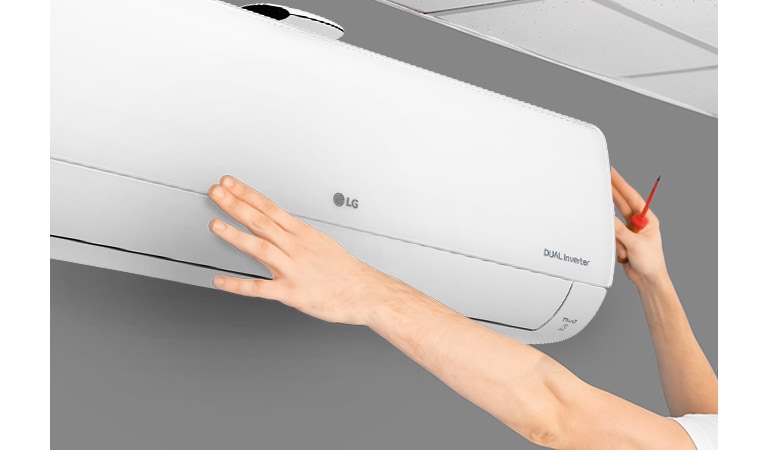 Вид збоку на кондиціонер, що встановлюють на стіні майже під стелею. Дві руки тягнуться вгору, одна тримає викруеку, демонструючи легкість встановлення.