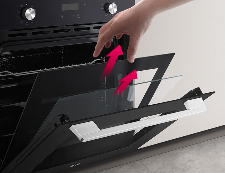 Духова шафа показана під кутом, дверцята частково відкриті. Рука тягнеться, щоб дістати скло. Різні шари скла дверцят розділені рожевими стрілками, що показують, що їх можна дістати окремо, щоб очистити.