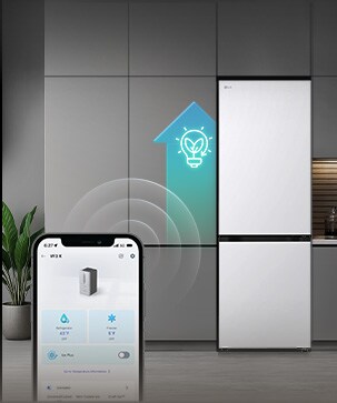 Холодильник LG з нижньою морозильною камерою (GC-B459QMYM) зі смартфоном на передньому плані, на екрані якого відображено застосунок ThinQ, а поруч із холодильником — сяючий світло-блакитний значок AI.