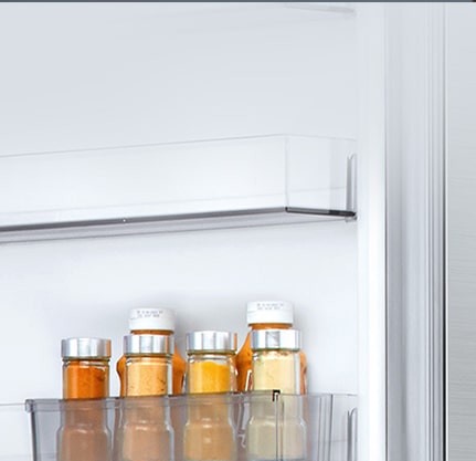 Зображено рухомий міні-кошик на дверцятах, в якому знаходиться шість маленьких пляшечок з соусом.