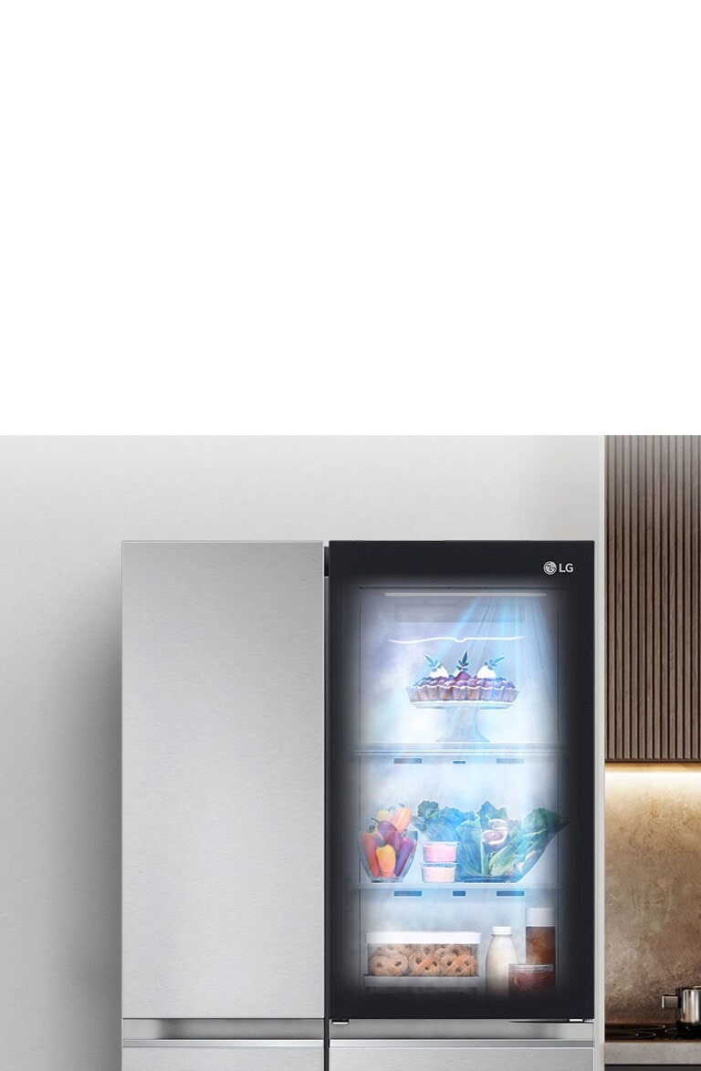 Показано холодильник в інтер'єрі кухні з підсвіченим віконцем у дверцятах, що дозволяє побачити вміст всередині на полицях. Також видно, як продукти в холодильнику обдуває свіже холодне повітря.