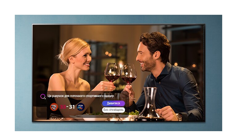 Чоловік і жінка чокаються бокалами на екрані телевізора, коли відображаються сповіщення про спортивні події