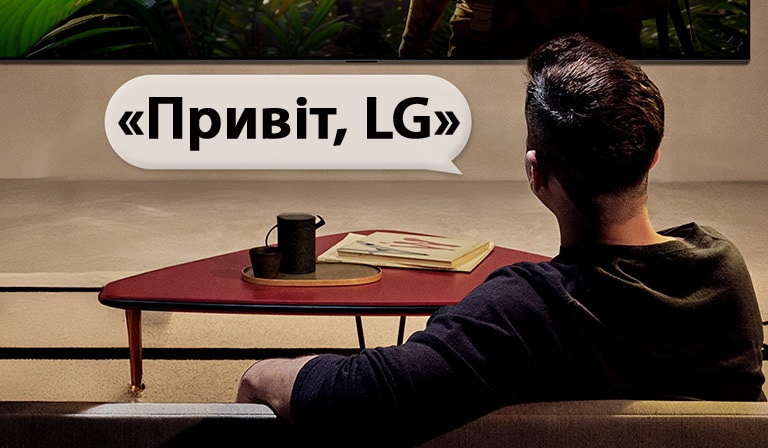 Людина знаходиться у своїй вітальні. Навколо неї з’являється діалогове вікно, яке показує, як вона взаємодіє з телевізором LG, просто кажучи: «Привіт, LG».