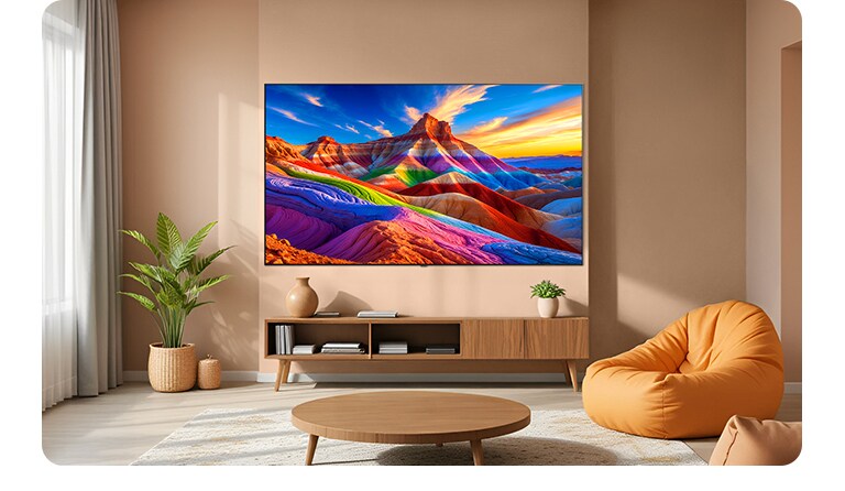 LG OLED AI B6 встановлений на стіну у стильному житловому просторі, має надтонкий дизайн з вузькими рамками та відображає на екрані пейзаж у райдужних тонах з багатошаровими гірськими формами.
