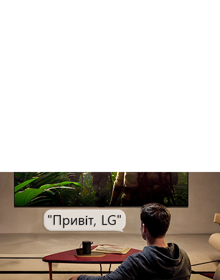 LG OLED AI B6 з функцією віддаленого голосового розпізнавання активується голосовою командою, коли людина, що сидить у кімнаті, каже «Привіт, LG» у бік телевізора, що свідчить про можливість взаємодії з інтерфейсом телевізора без використання рук