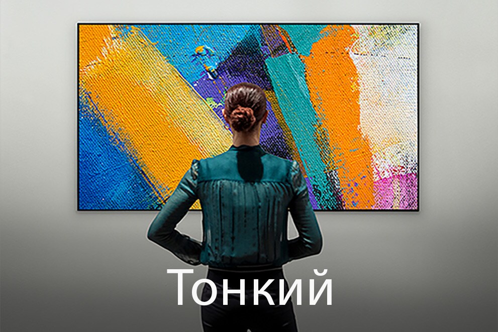 Зображення жінки, що стоїть спиною до глядача й дивиться на телевізор серії Gallery Design, з підписом «Тонка конструкція»