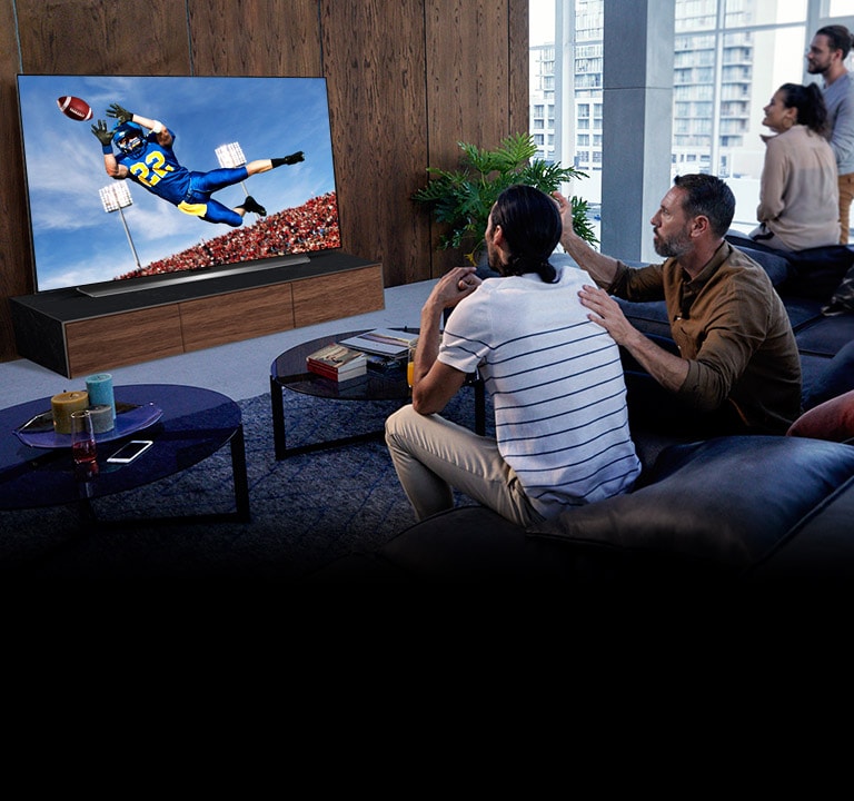 Люди, які спостерігають гру "Тоттенхем" по телевізору у вітальні