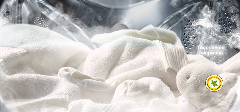 М’який білий халат і м'яка іграшка зображені з парою в барабані пральної машини.