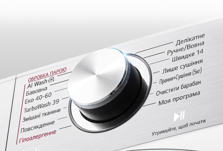 Це збільшене зображення металевої ручки на панелі пральної машини.