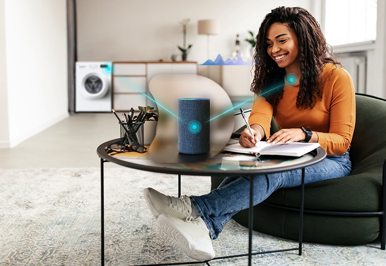 Жінка, яка керує пральною машиною з голосовим асистентом
