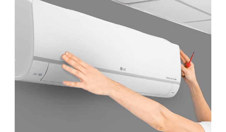 Вид збоку на кондиціонер, що встановлюють на стіні майже під стелею. Дві руки тягнуться вгору, одна тримає викруеку, демонструючи легкість встановлення.