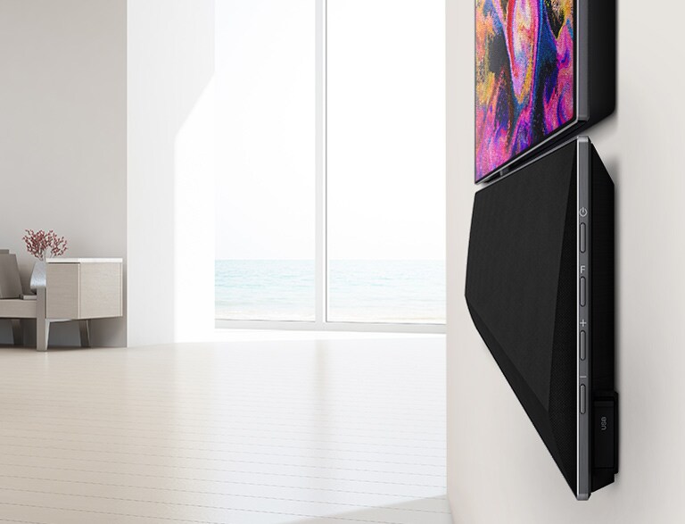 Великий план настінного телевізора і саундбара LG. На екрані телевізора відображаються різні рожеві кольори.