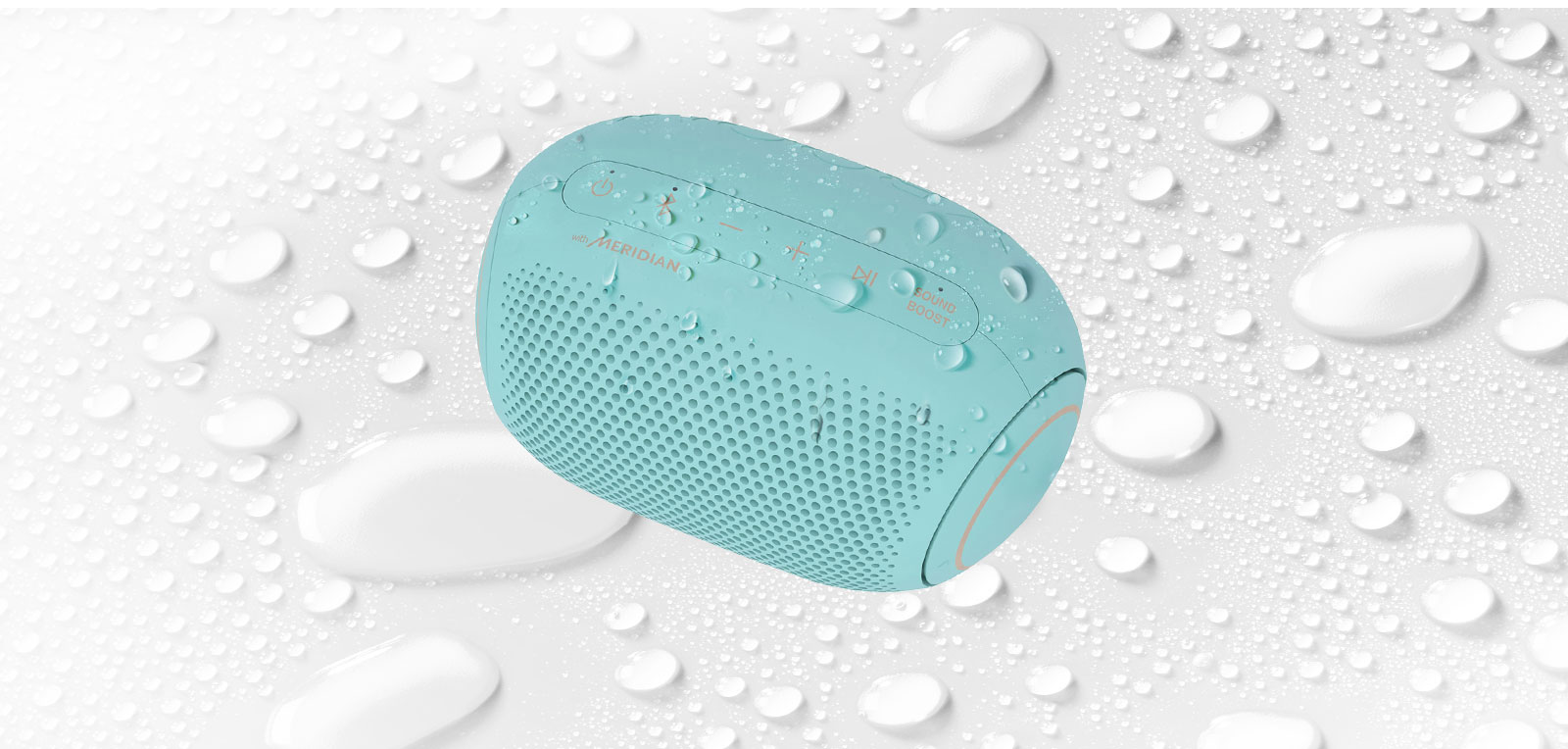 On a white background, LG XBOOM Go is facing up to the left. There are water droplets on and underneath LG XBOOM Go.