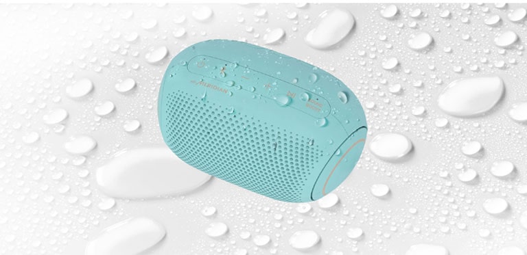 On a white background, LG XBOOM Go is facing up to the left. There are water droplets on and underneath LG XBOOM Go.