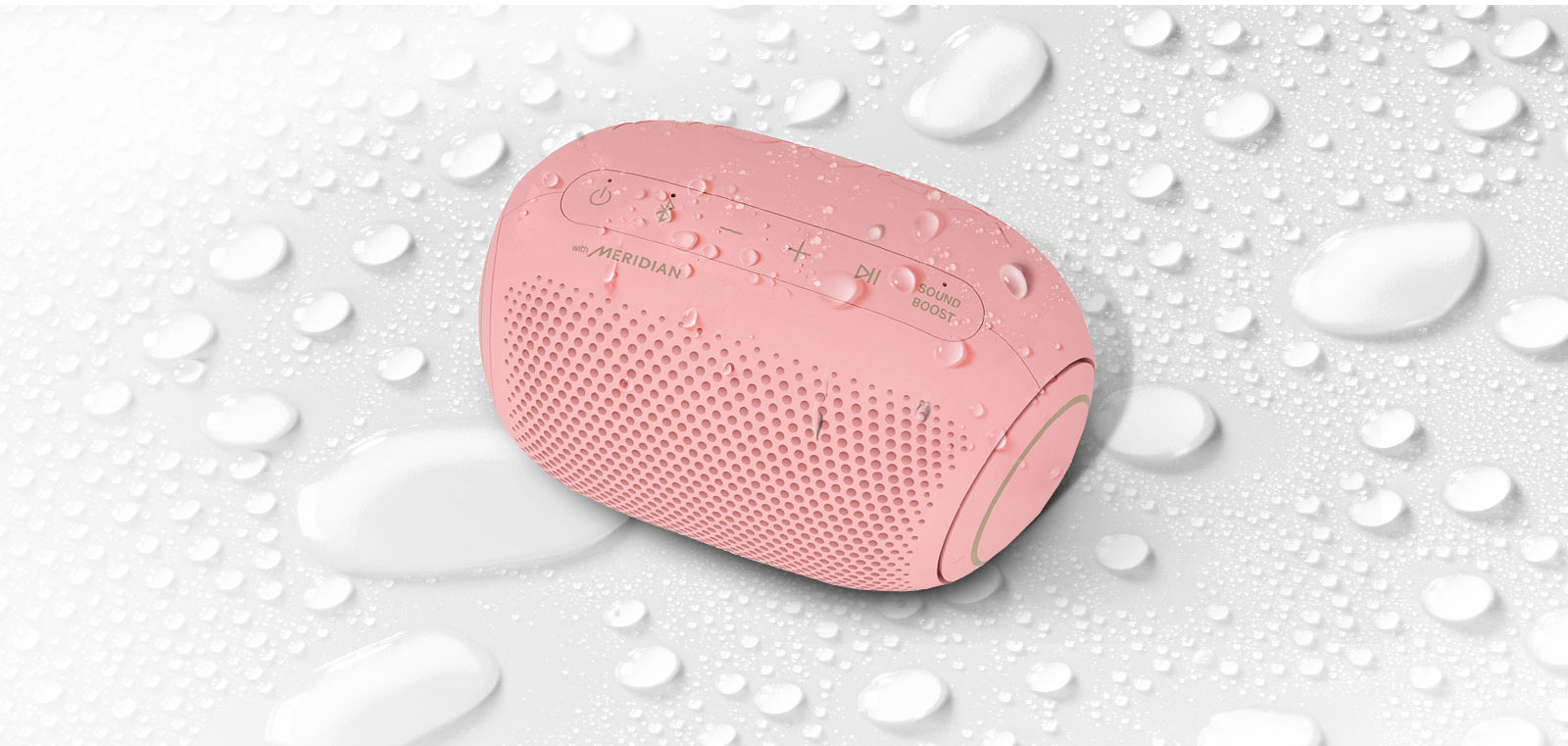 On a white background, LG XBOOM Go is facing up to the left. There are water droplets on and underneath LG XBOOM Go.