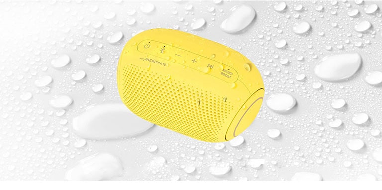 On a white background, LG XBOOM Go is facing up to the left. There are water droplets on and underneath LG XBOOM Go.