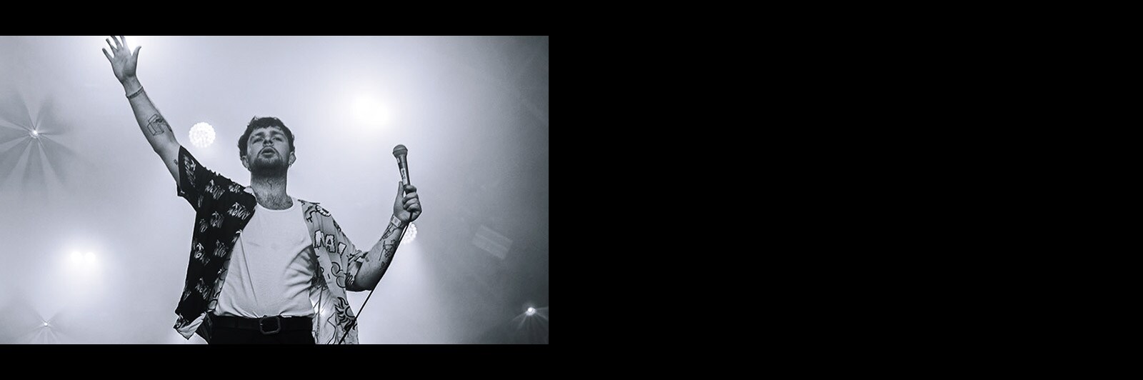 Музикант, що стоїть на сцені з прожектором на ньому