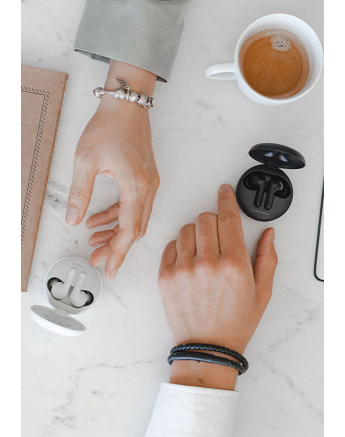 Чоловік тягнеться до чорних навушників, а жінка - до білих