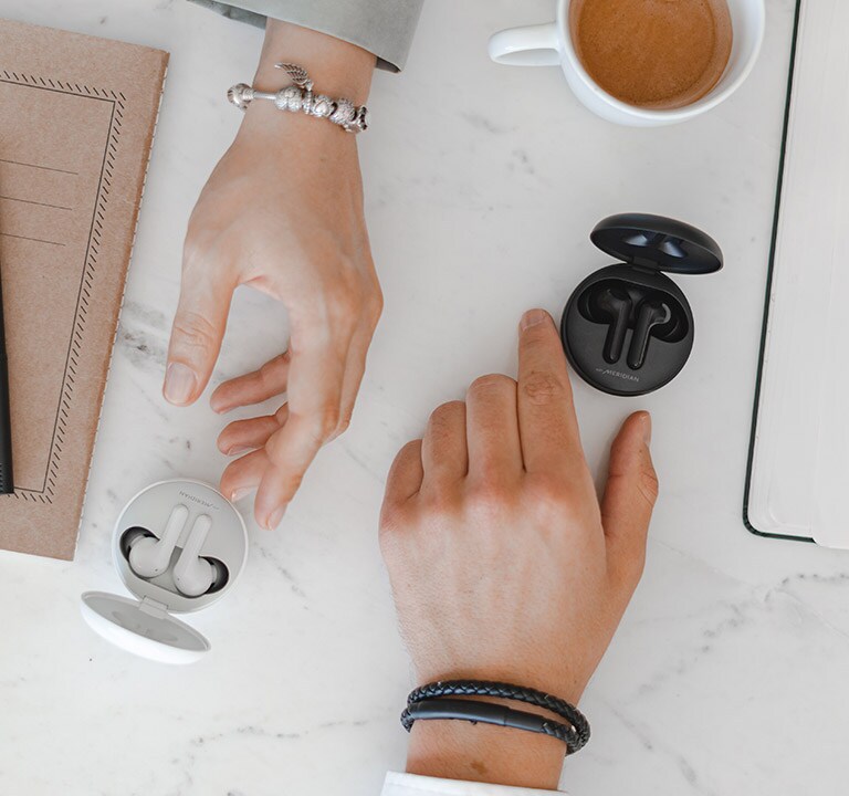 Чоловік тягнеться до чорних навушників, а жінка - до білих