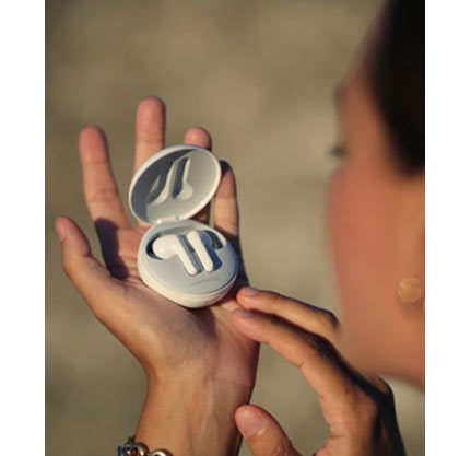 Жінка, дивлячись на навушники, тримаючи її на руці