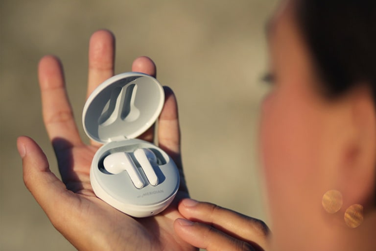 Жінка, дивлячись на навушники, тримаючи її на руці