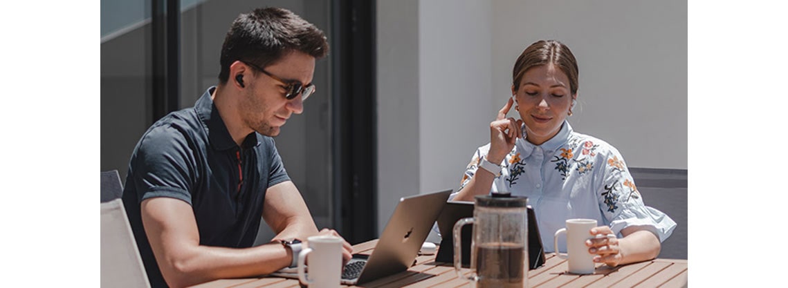 Чоловік і жінка носять навушники на терасі