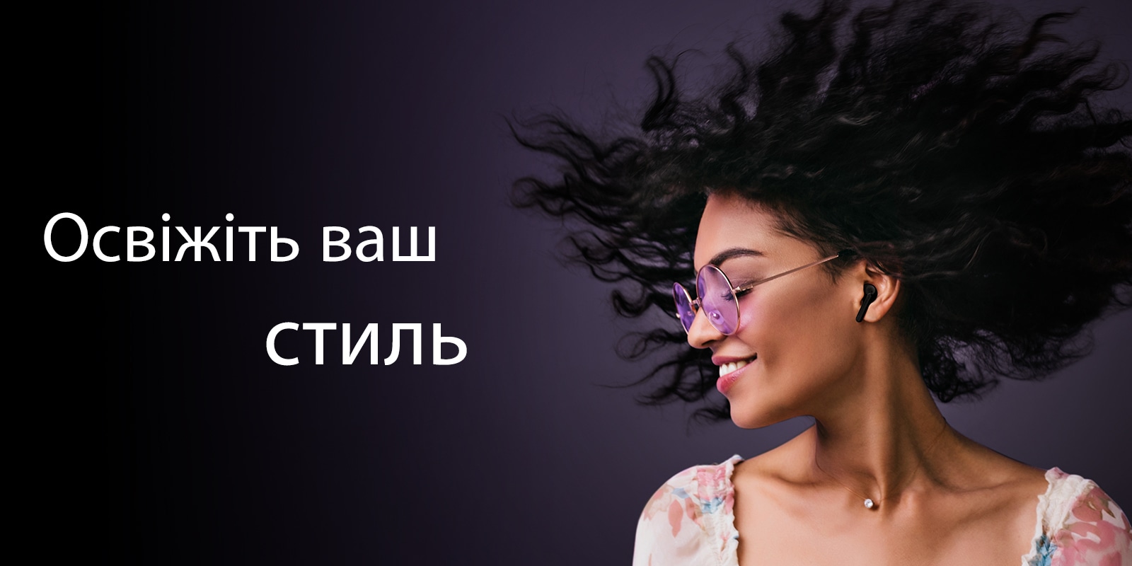 Жінка посміхається, слухаючи музику в навушниках TONE Free.