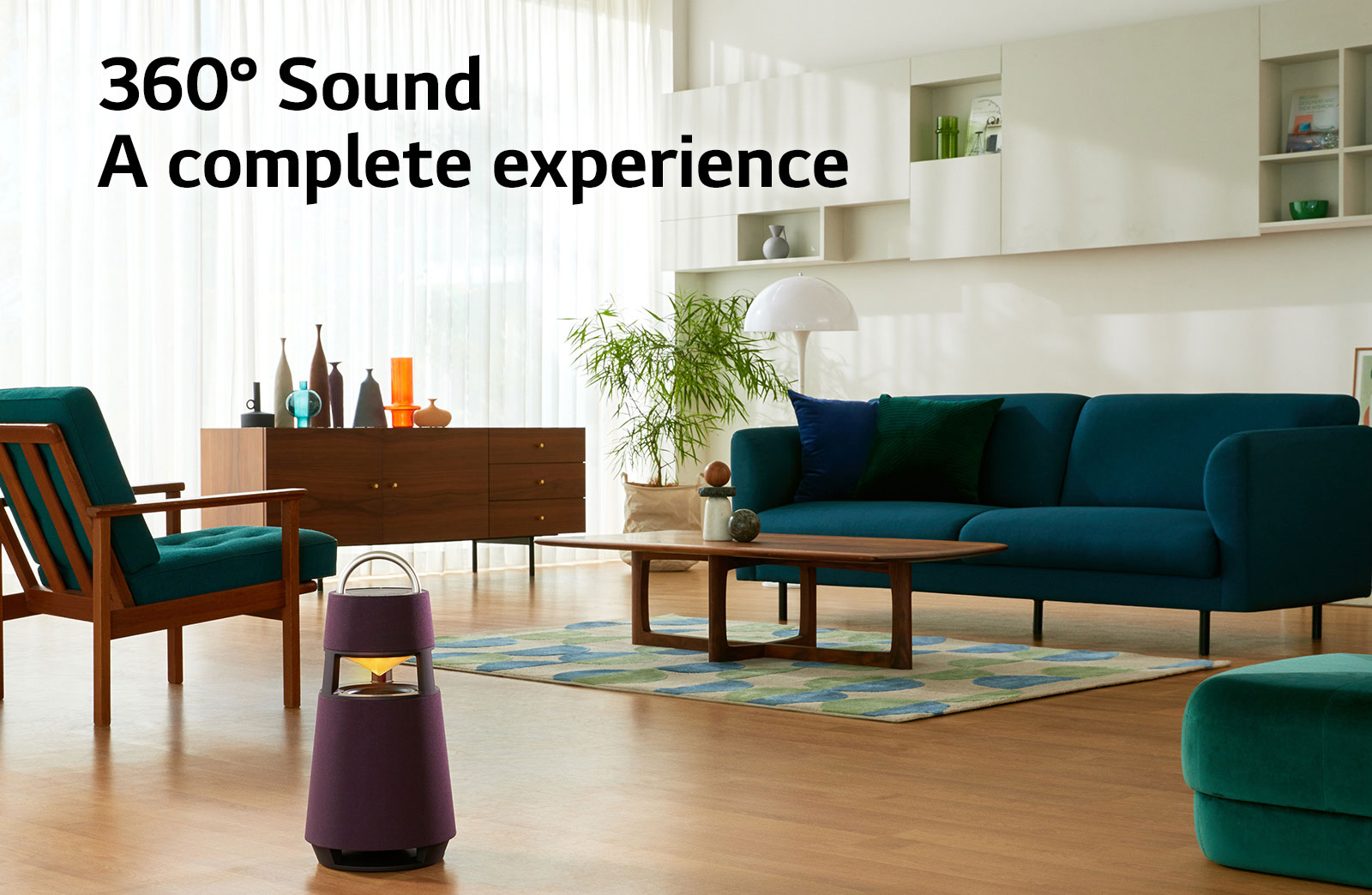 Зображення жінки, що сидить на дивані за колонкою XBOOM 360 і слухає музику.