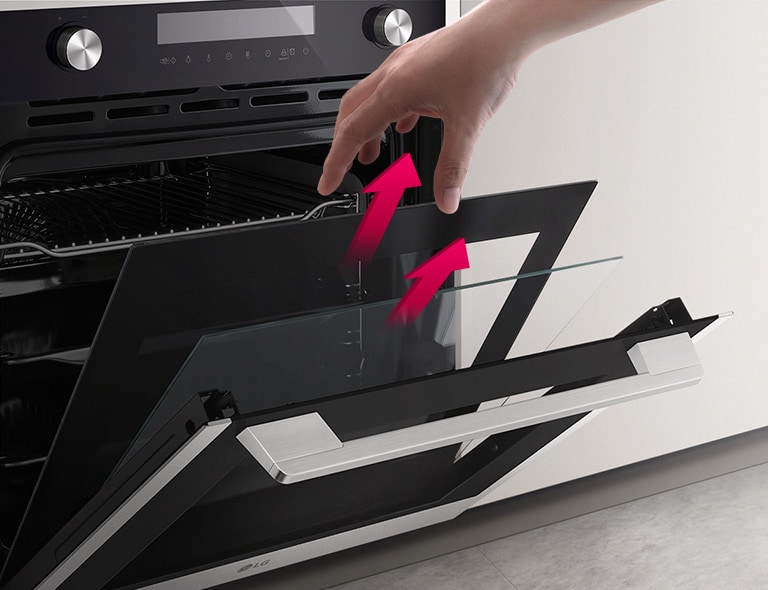 Духова шафа показана під кутом, дверцята частково відкриті. Рука тягнеться, щоб дістати скло. Різні шари скла дверцят розділені рожевими стрілками, що показують, що їх можна дістати окремо, щоб очистити.