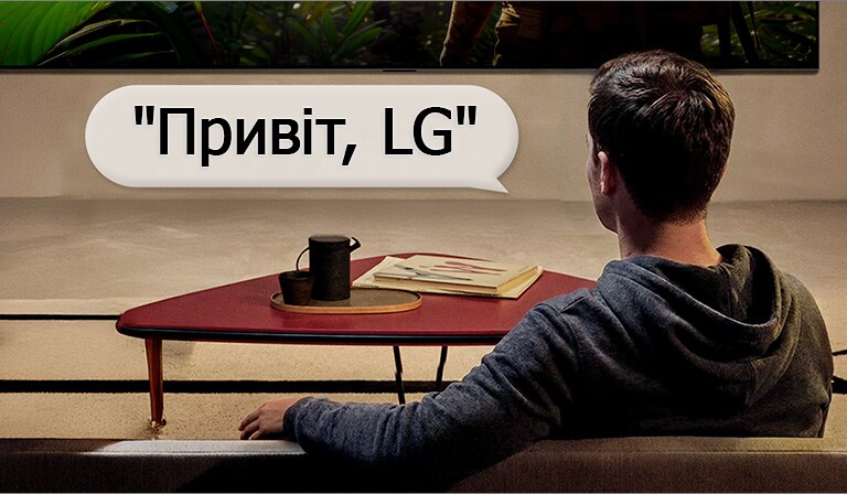 Людина у своїй вітальні. Навколо них з’являється підказка, яка показує, як вона взаємодіє з LG TV, просто кажучи: "Привіт, LG".