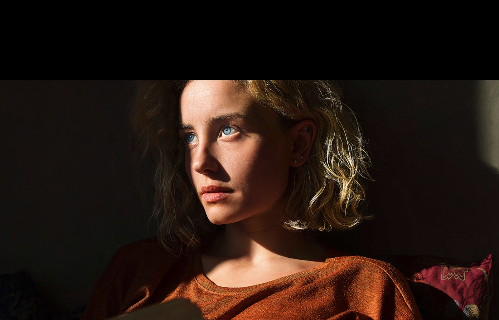 Червона неонова лінія повторює контур зображення жінки, потім прокручується по екрану, і зображення стає яскравішим. Потім лінія прокручується позаду зображення жінки.