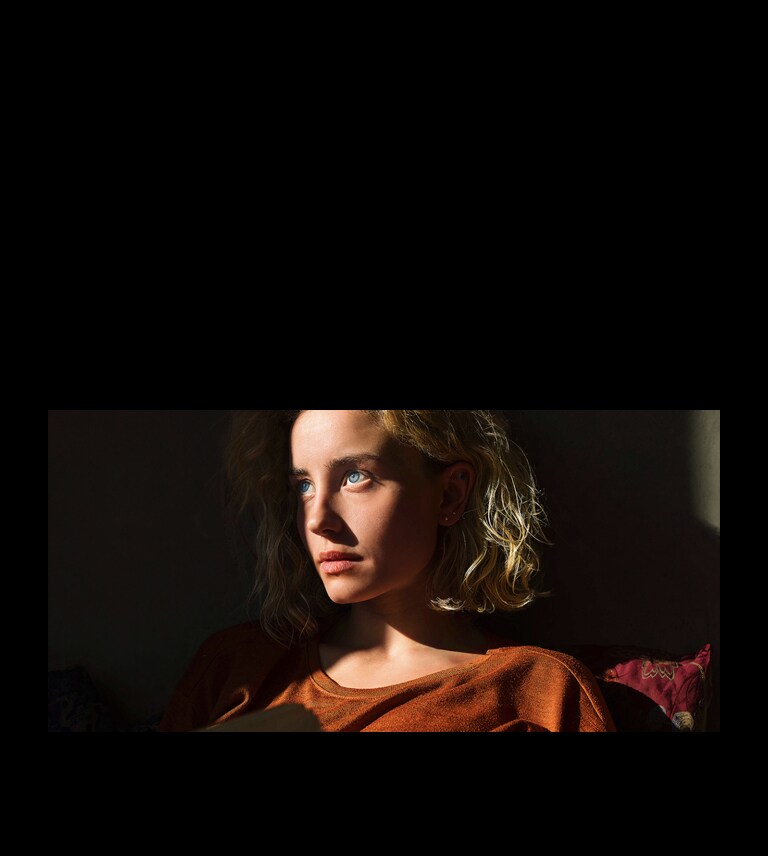 Червона неонова лінія повторює контур зображення жінки, потім прокручується по екрану, і зображення стає яскравішим. Потім лінія прокручується позаду зображення жінки.