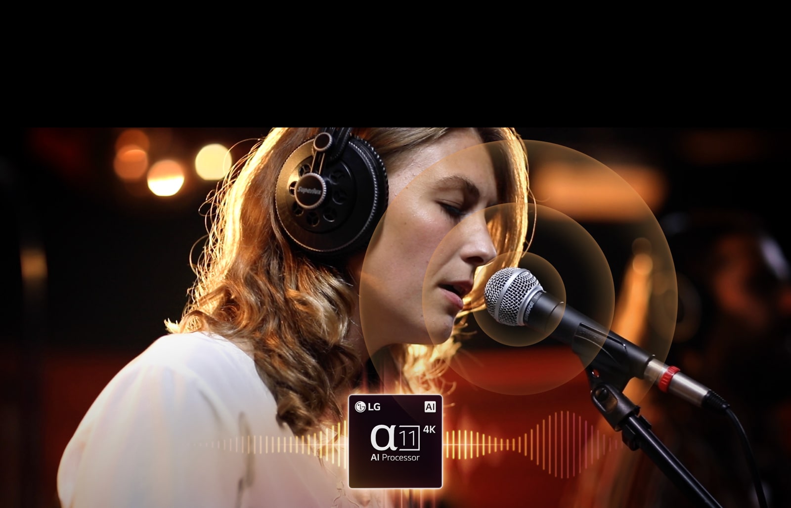 Процесор LG alpha 11 AI Processor 4K розташовано в центрі внизу, а з нього випромінюється звукова хвиля. Позаду жінка співає в мікрофон, а з мікрофона випромінюються кола. Кадр переміщується ліворуч до гітари, а коли грають на струнах, то випромінюються графічні кола.