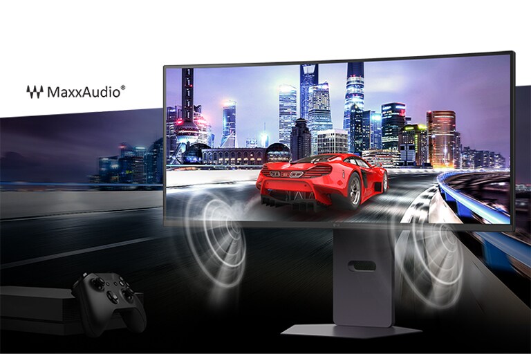 Червоний гоночний автомобіль мчить дорогою на тлі міста, оточеного чудовими високими будівлями, з монітором Ultra Gear попереду та ігровим контролером унизу ліворуч. Звук динамічно відтворюється через динаміки MaxxAudio з обох боків монітора.