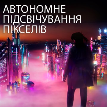 Жінка вночі дивиться на міський пейзаж із барвистими неоновими вивісками.