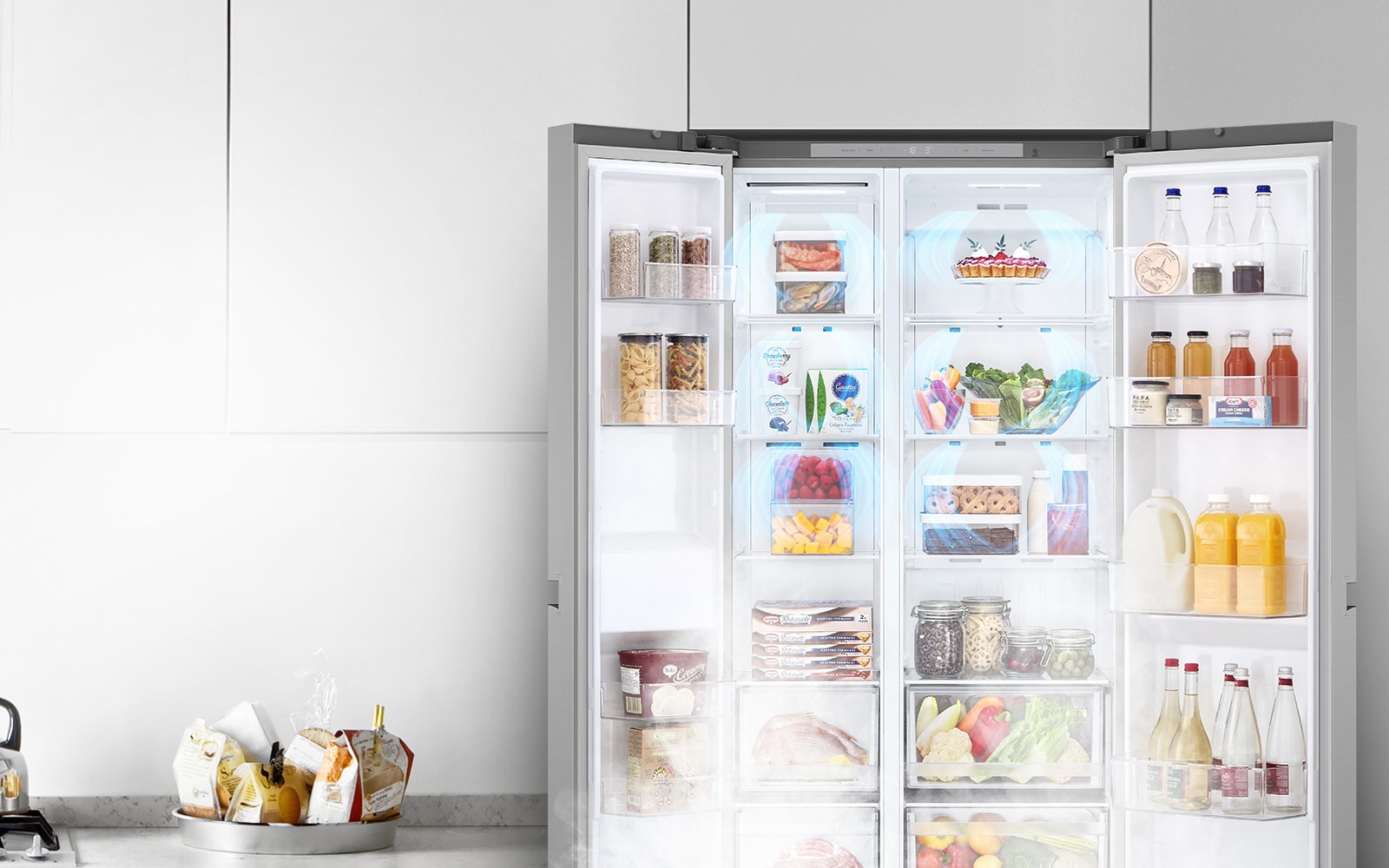 Показано відкритий холодильник в інтер'єрі, анімація блакитного повітря, яке розповсюджується по холодильнику і обдуває продукти в холодильнику.