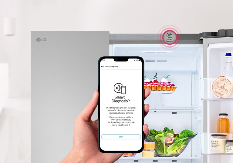На зображенні видно, що дверцята холодильника залишили відкритими. На  передньому плані зображено руку, що тримає смартфон, на якому видно інтерфейс програми Smart Diagnosis.